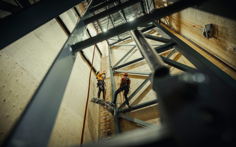 To personer øver på taubruk og tilkomstteknikk i en installasjon/hall